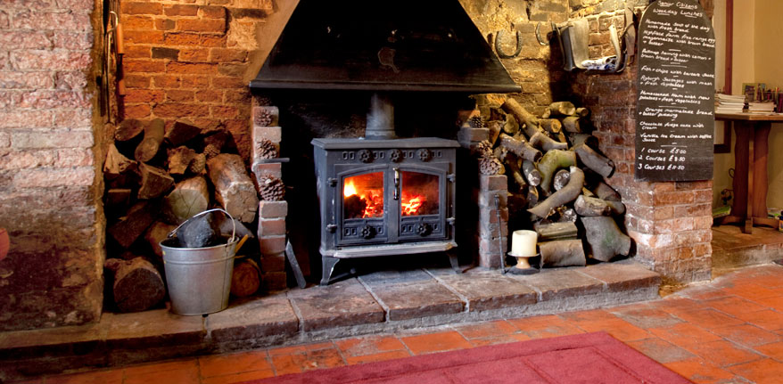The original inglenook fireplace with wood-burning stove at The Blue Boar Inn